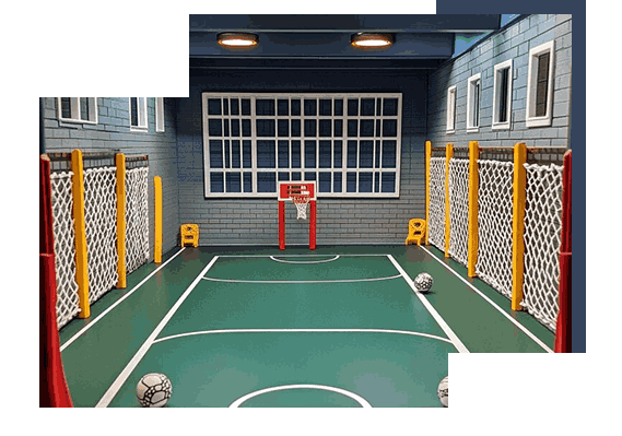 Mini indoor sports court with basketball hoop and soccer goals.