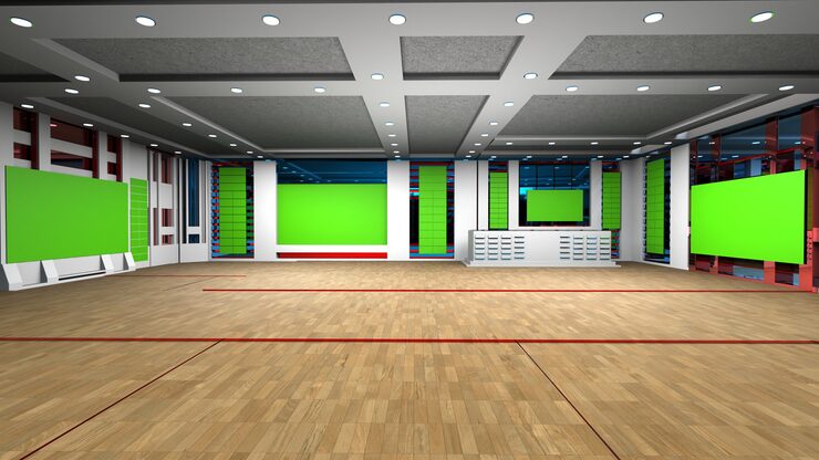Modern indoor sports facility with wooden flooring and green screen areas.
