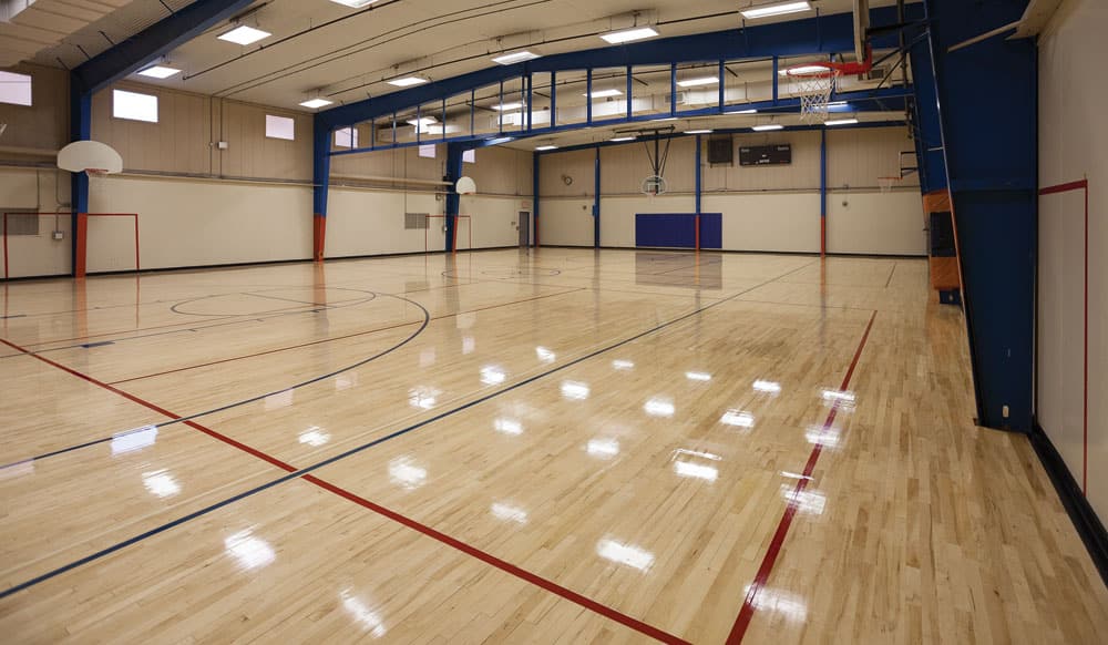 sports flooring in indoor basketball court with markings.