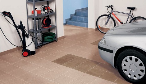 Garage with red tile flooring and a parked motorcycle