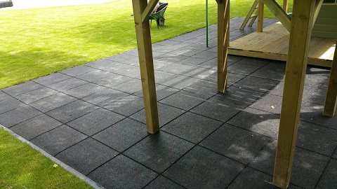 Black rubber tiles installed under a wooden play structure
