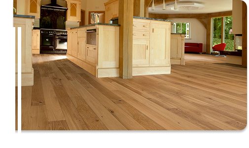 Engineered wood flooring in a spacious kitchen with light wood cabinets