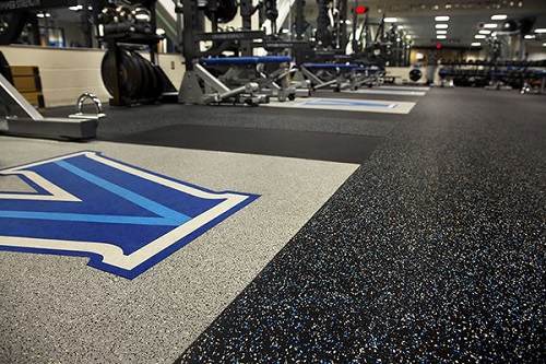 Gym flooring with custom logo platforms and speckled rubber tiles