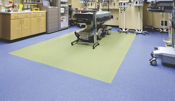 Hospital room with blue flooring and a green central floor section