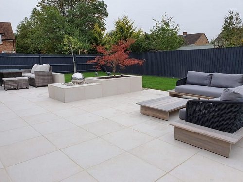 Modern patio with large beige tiles and outdoor seating