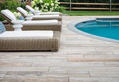 Poolside with wood-look tiles and wicker loungers