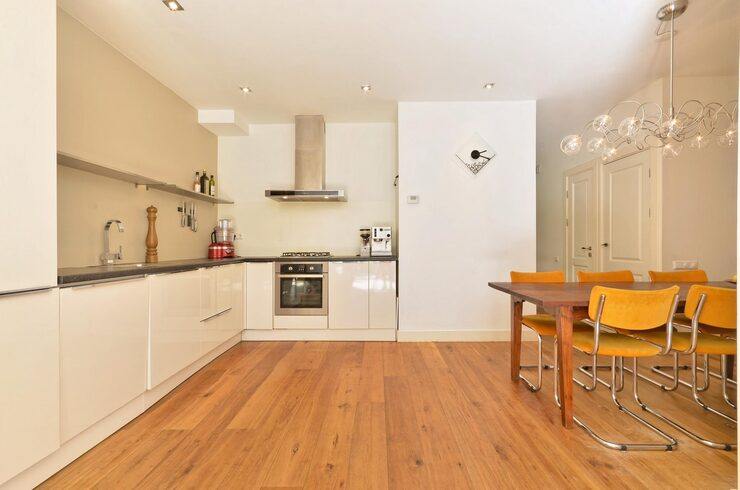 Modern kitchen with warm wooden flooring and dining table