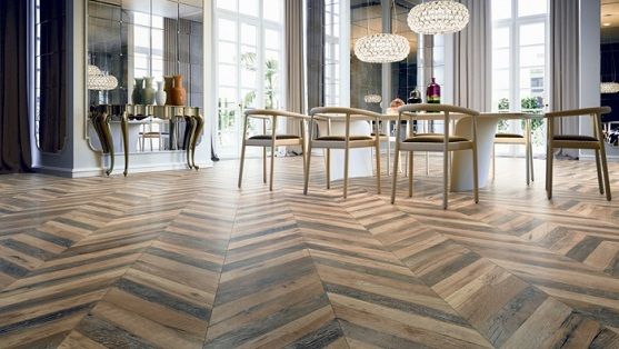 Chevron wooden flooring in a stylish dining room with large windows