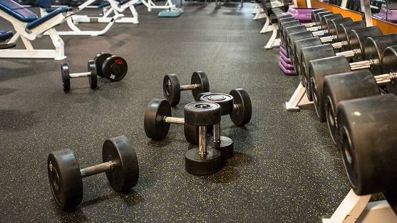 Dumbbells on black EPDM gym flooring with yellow speckled surface