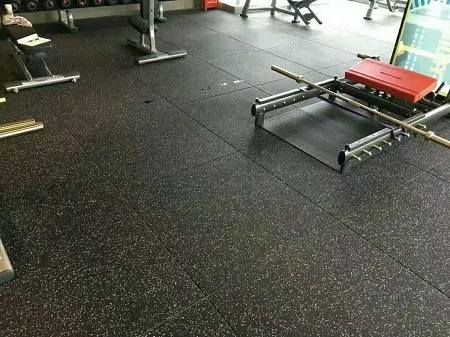 EPDM gym flooring with black tiles and white speckles in fitness area