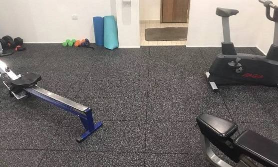 Home gym setup with grey EPDM interlocking tiles under exercise machines