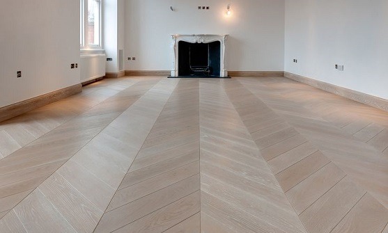 Light chevron wooden flooring in a modern empty living room