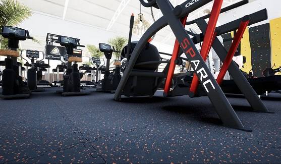 Modern gym with black EPDM rubber tiles featuring orange speckles